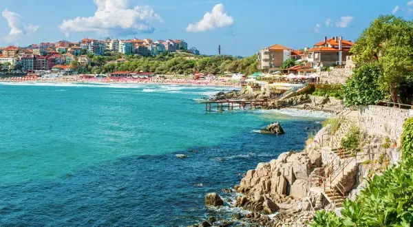Słoneczne bułgarskie miasta turystyczne nad turkusowym morzem. Widok na plażę, klify i zabudowania.