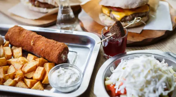 Sycące dania serbskie: panierowany roladek z ziemniakami, burger i sałatka. Idealne na obiad.