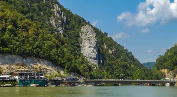 Wielka twarz wyrzeźbiona w skale, symbolizująca Żelazną Bramę, góruje nad rzeką.