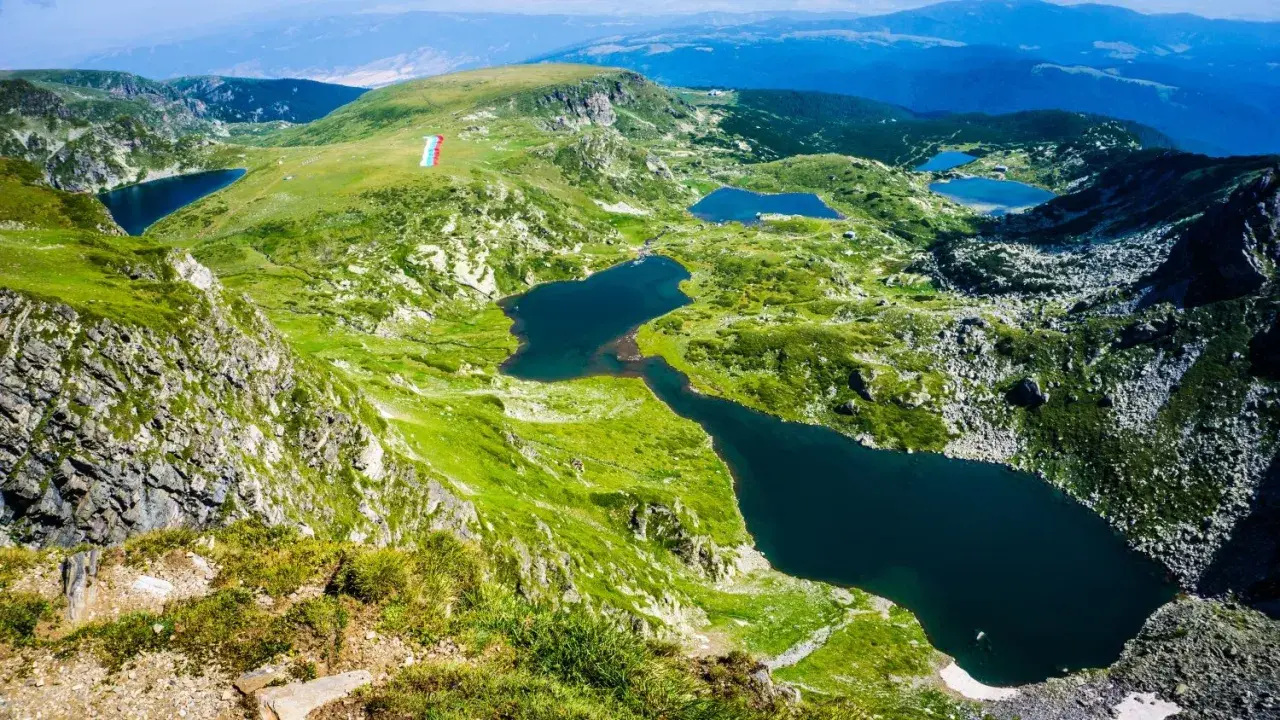Siedem Rilskich Jezior w górach Pirin, otoczonych zielonymi zboczami i skalistymi szczytami.