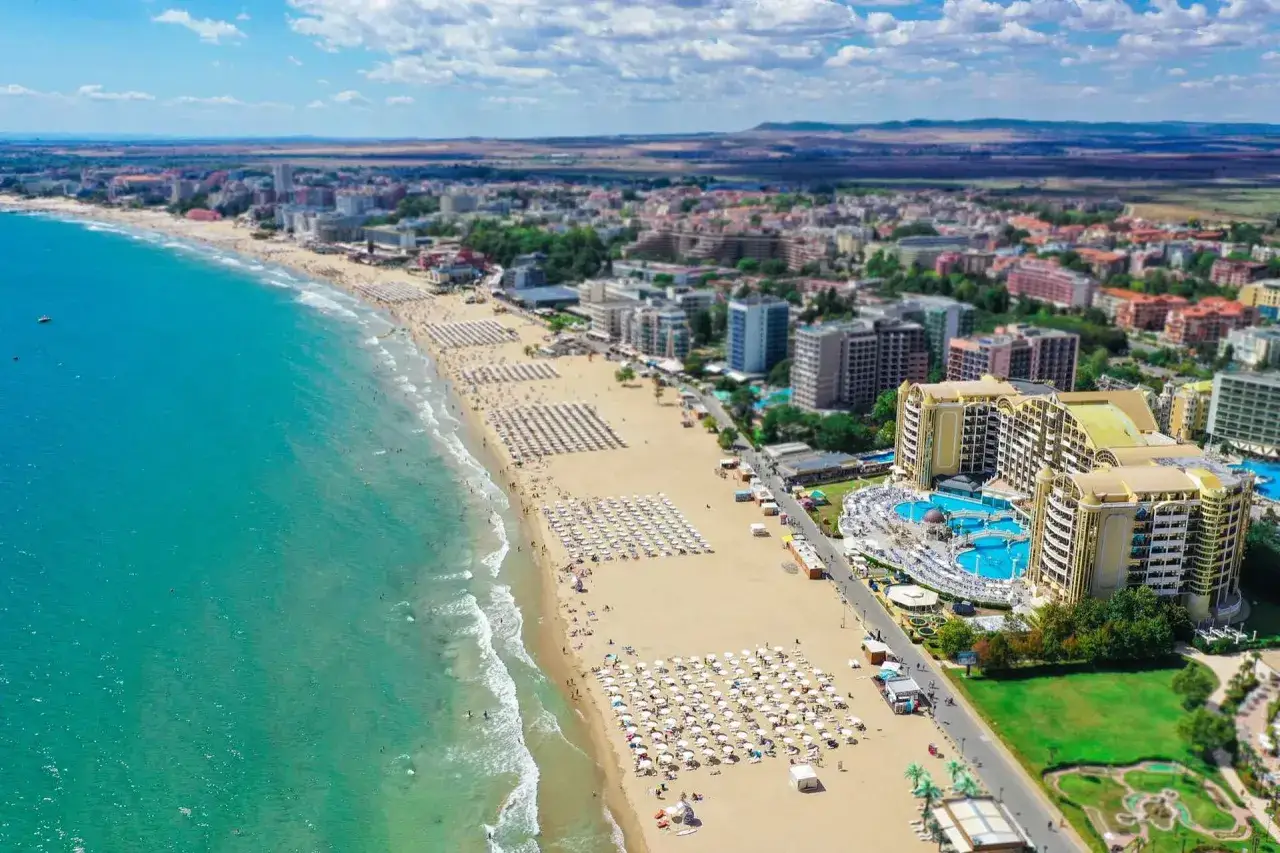 Słoneczna plaża w Bułgarii, z turkusowym morzem i luksusowym hotelem. Idealne miejsce na wakacje!