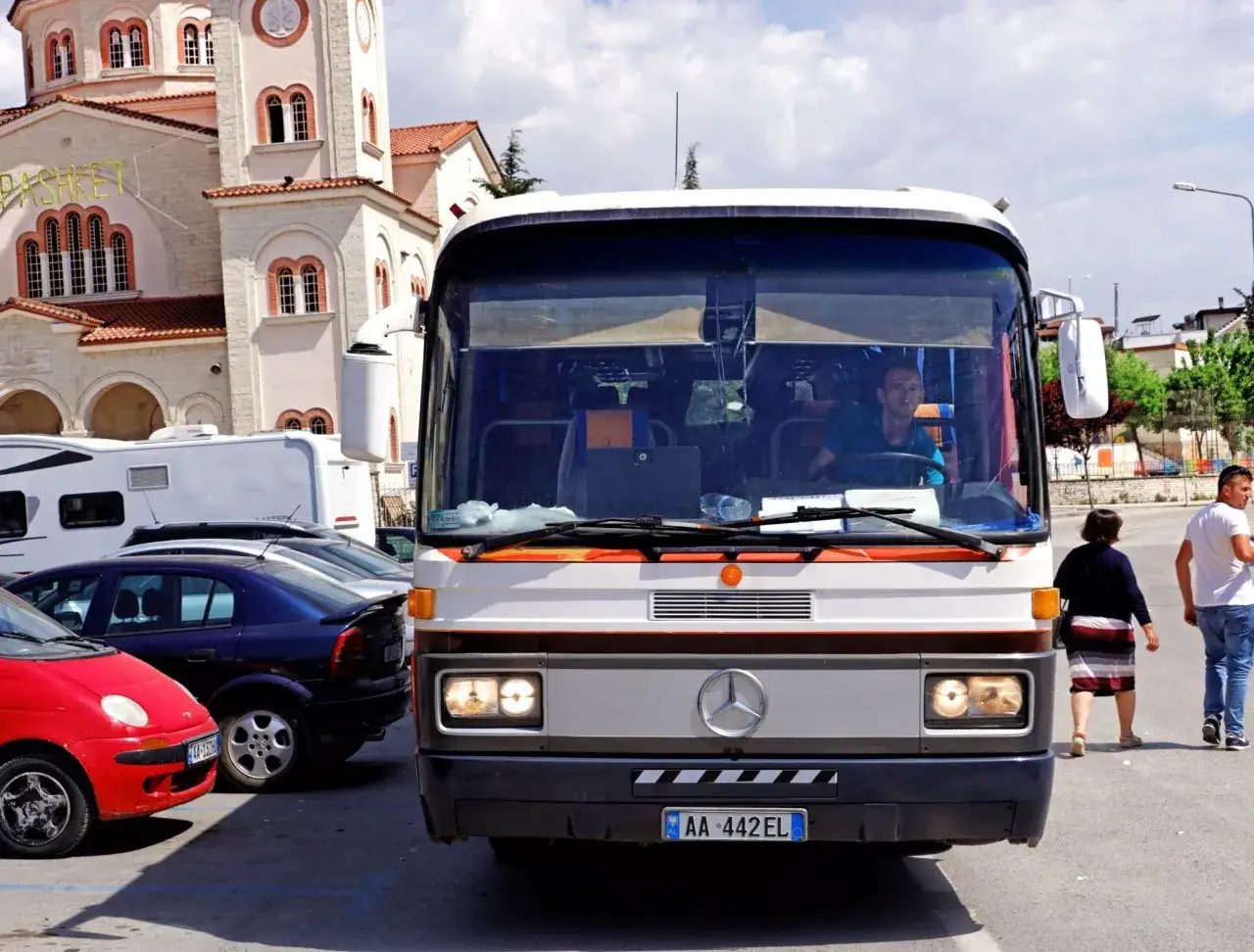 Autobus Mercedes-Benz na tle cerkwi w Albanii. Ten transport to część podróży po Bałkanach.