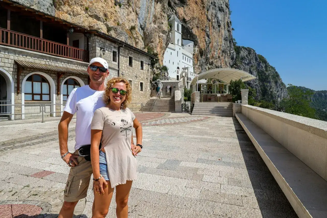 Para zwiedza monaster Ostrog, wbudowany w skalne zbocze.