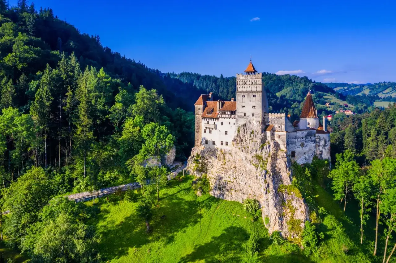 Zamek w górach, Rumunia, Transylwania. Majestatyczna twierdza na skale, otoczona zielonymi lasami i wzgórzami.