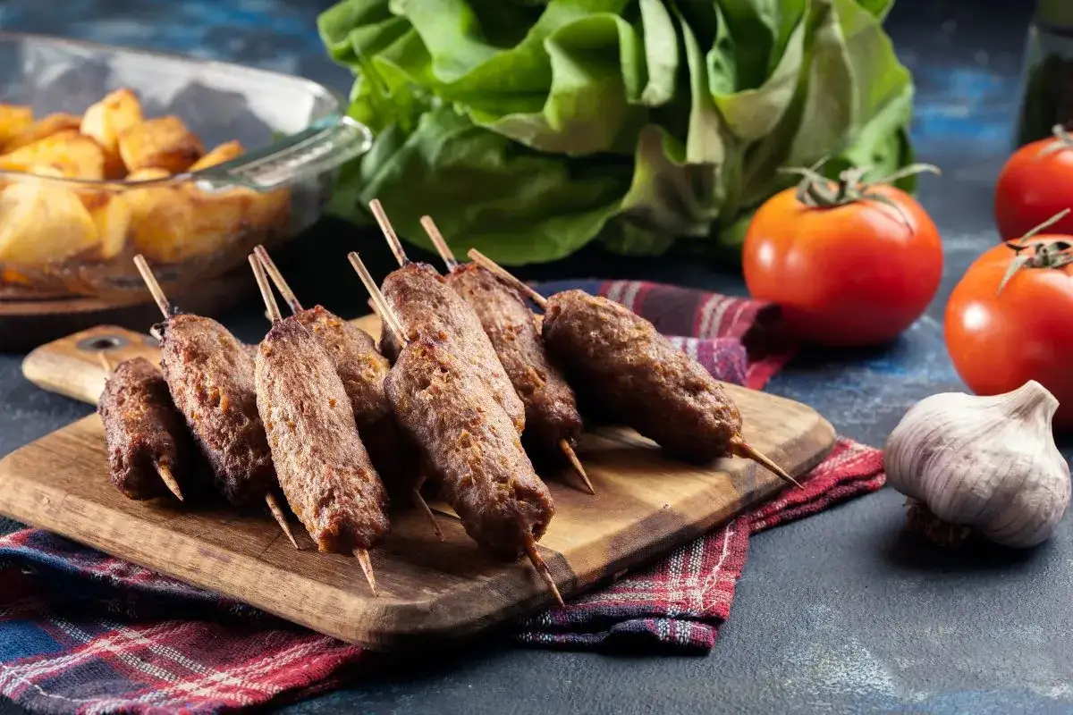 Pyszne cevapcici na patyczkach, gotowe do podania. Idealne na grilla, z pieczonymi ziemniakami i świeżymi warzywami.