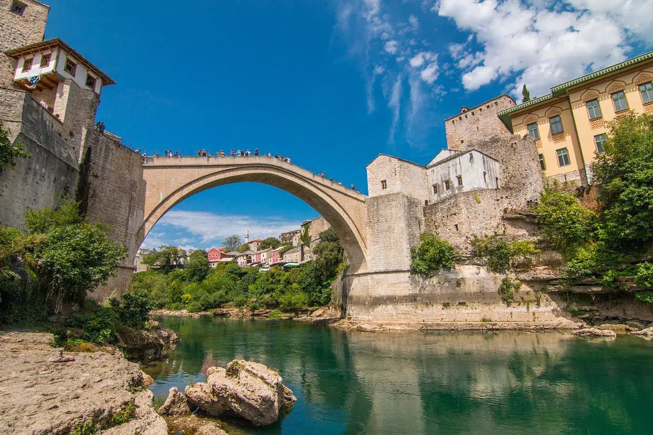 Mostar, Bośnia i Hercegowina. Tłumy turystów na Starym Moście. Ceny w Bośni i Hercegowinie są przystępne, a widoki zapierają dech.