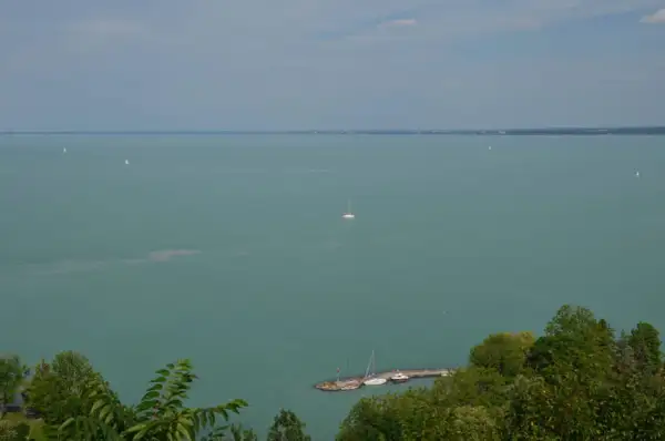 Widok na Balaton z Tihany. Żaglówki na turkusowej wodzie, molo z łodziami. Tihany atrakcje zachwycają.