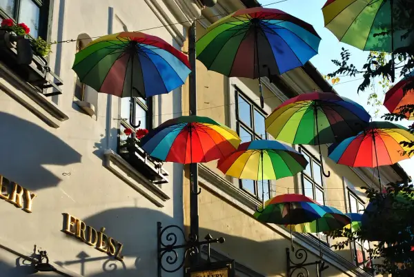Kolorowe parasole unoszą się nad ulicą, tworząc radosną atmosferę. To jedna z urokliwych szentendre atrakcji, która przyciąga wzrok.