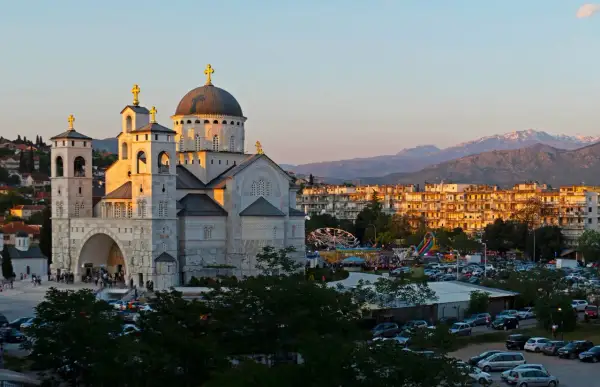 Podgorica atrakcje: monumentalna cerkiew i wesołe miasteczko w blasku zachodzącego słońca.