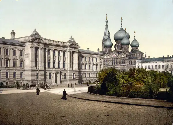 Dawne budynki i cerkiew na brukowanym placu, świadczące o tym, gdzie leży Odessa. Ludzie spacerują, a powozy stoją.
