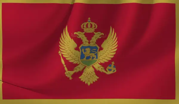 Flaga Czarnogóry z dwugłowym orłem. W tym kraju obowiązuje euro jako waluta, a język urzędowy to czarnogórski.