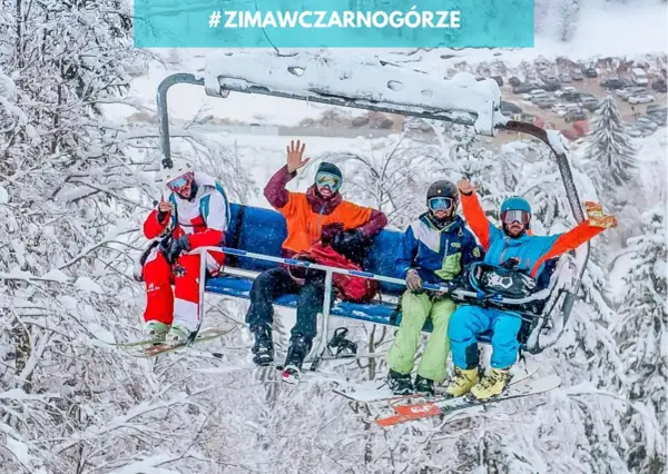 Czterech narciarzy na wyciągu krzesełkowym cieszy się zimą w Czarnogórze. W tle zaśnieżone drzewa i parking.