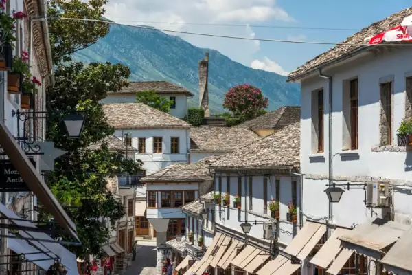 Kamienne dachy i białe domy w Gjirokastrze, Albania. W tle góry, idealne na jesienny spacer.