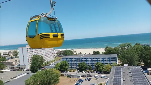 Żółta kolejka linowa nad kurortem z widokiem na piękne **konstanca plaże** i błękitne morze.