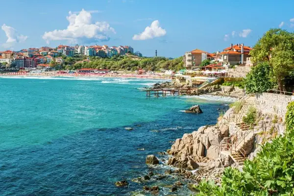 Słoneczne bułgarskie miasta turystyczne nad turkusowym morzem. Widok na plażę, klify i zabudowania.