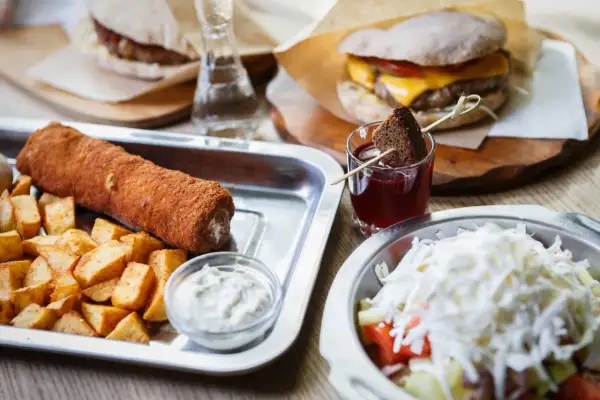 Sycące dania serbskie: panierowany roladek z ziemniakami, burger i sałatka. Idealne na obiad.