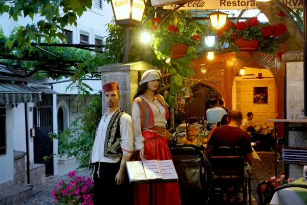 Manekiny w strojach ludowych przed restauracją w Sarajewie. Sprawdzamy sarajewo ceny, by wybrać najlepsze miejsce na posiłek.